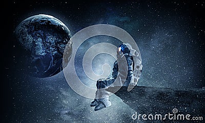 Spaceman on rock edge. Mixed media Stock Photo
