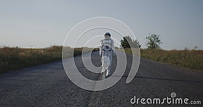 Astronaut walking on road Stock Photo