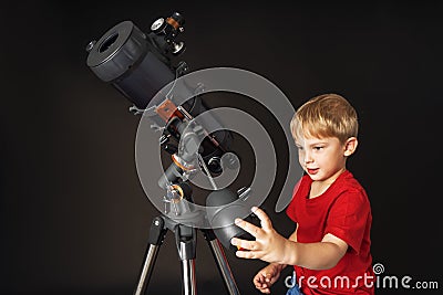 A little boy himself adjusts a large telescope. Stock Photo