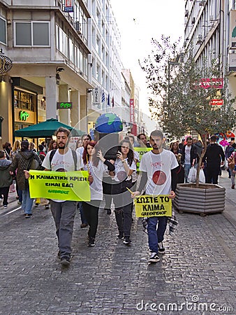 Athens / Greece - November 02 2019: Greenpeace young protesters hold banners about climate change and carry a black coffin with a Editorial Stock Photo