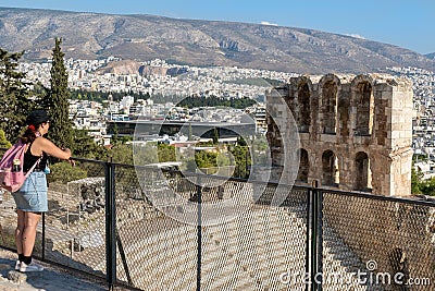 Athens, Greece-Sep 1, 2021: Young lady is admiring the view to the Odeon of Herodes Atticus or Herodion, the Acropolis Museum Editorial Stock Photo