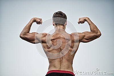 Athlete with bare torso on grey sky Stock Photo