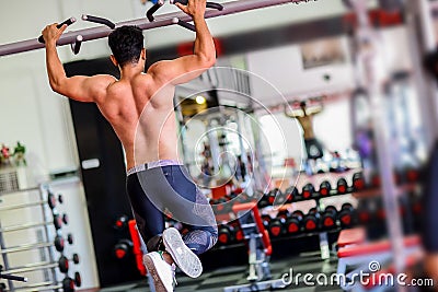 Athlete muscular fitness male model pulling up on horizontal bar Stock Photo