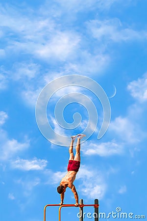 Athlete performs a handstand on the uneven bars. Copy space. Stock Photo