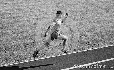 Athlete run track grass background. Sprinter training at stadium track. Runner captured in midair. Short distance Stock Photo