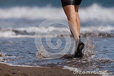 Athlete runner running on waves of sea Stock Photo