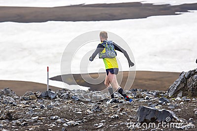 Athlete runners run a mountain marathon in the snowy terrain of Landmannalaugar. Iceland Editorial Stock Photo