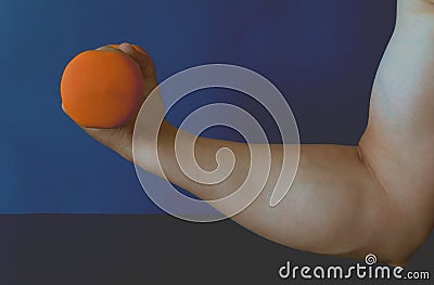 The athlete's hand raises an orange kettlebell. Stock Photo