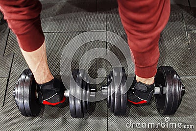 Athlete taking dumbbells from floor, man pov Stock Photo