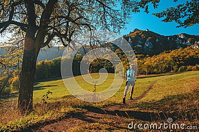 Athlete trains in warm orange sunrise light. Running in beautiful autumn nature Editorial Stock Photo