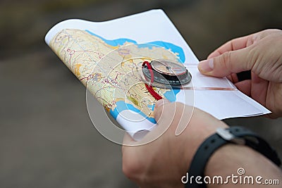 Athlete uses navigation equipment for orienteering,compass and topographic map Stock Photo