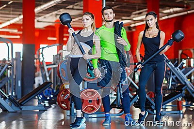 Athletes in the gym are posing with a hammer and a rope. Stock Photo