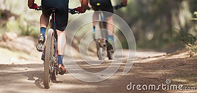 Athletes mountain biking on forest trail Stock Photo