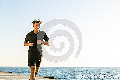 athletic adult joger running on seashore Stock Photo