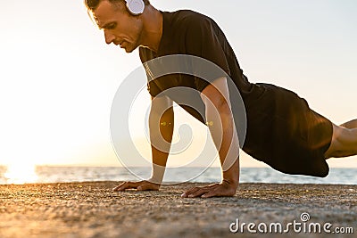 athletic adult man in headphones doing push ups Stock Photo