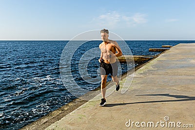 athletic adult shirtless man jogging Stock Photo