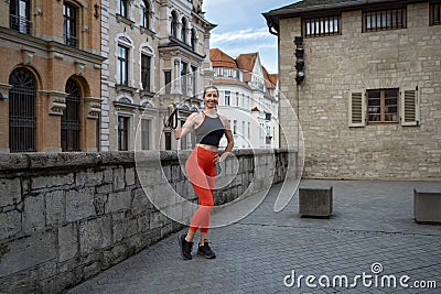 Athletic beautiful woman during fitness class in old european city Stock Photo