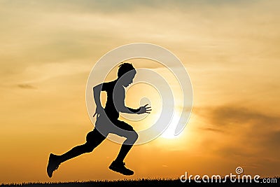 Silhouette of boy running at sunset. Stock Photo