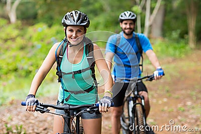 Athletic couple cycling in forest Stock Photo