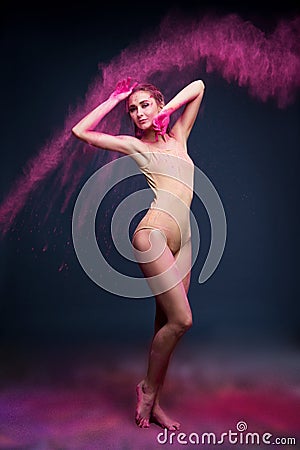 Athletic dancer girl in a cloud of pink paint on stage Stock Photo