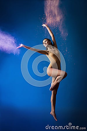 Athletic dancer girl in a cloud of pink paint on stage Stock Photo