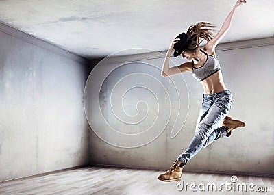 Athletic dancer jumping on a concrete wall background Stock Photo