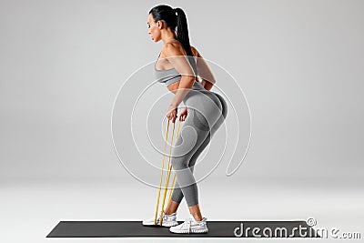 Athletic girl doing exercise with resistance band. Fitness woman working out Stock Photo