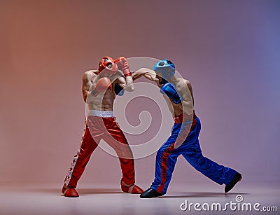 Athletic guys fighting, wearing boxing gloves on red blue studio background with copy space, mixed fight concept Stock Photo