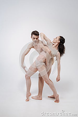 Athletic gymnasts performing in the white colored studio Stock Photo