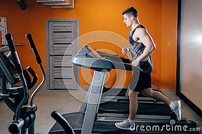 Athletic man running on the treadmill Stock Photo