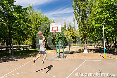 Athletic Man Taking Jump Shot on Basketball Court Stock Photo