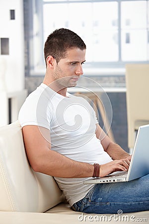 Athletic man using laptop at home Stock Photo