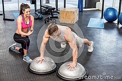 Athletic man working out helped by trainer woman Stock Photo