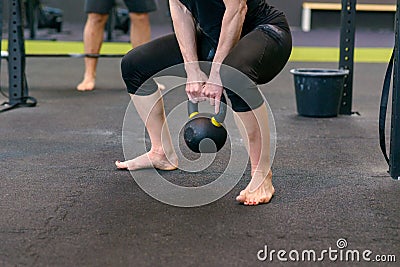 Athletic muscular woman lifting kettle weights Stock Photo