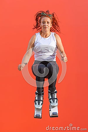 Athletic redhead Latin woman jumping wearing Kangoo Jumps boots Stock Photo