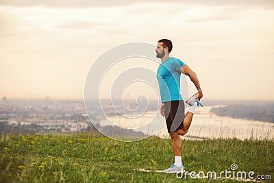 Athletic runner doing stretching exercise Stock Photo