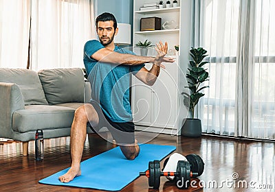 Athletic and sporty man doing warmup at gaiety home exercise. Stock Photo