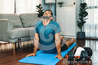 Athletic and sporty man doing warmup at gaiety home exercise. Stock Photo