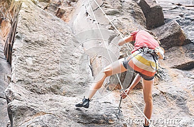 Athletic strong man climbing a rock wall - Climber performing on a canyon mountain Stock Photo