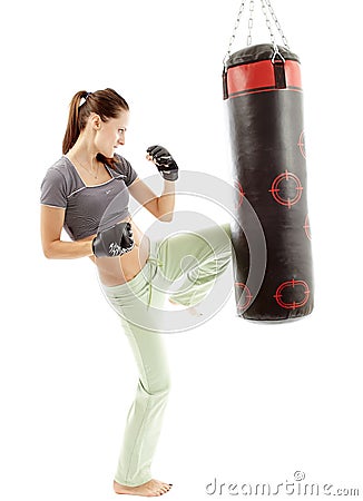 Athletic woman kicking the punching bag Stock Photo