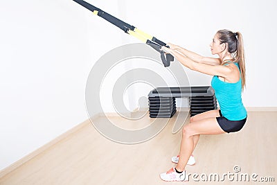 Athletic woman makes TRX exercise Stock Photo