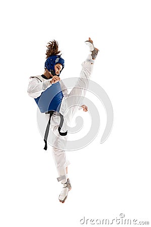 Athletic young girl in dobok and blue helmet practicing, training taekwondo isolated over white background Stock Photo