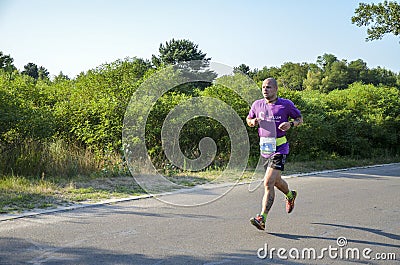 Athletic young man running in the nature. Urban healthy active lifestyle Editorial Stock Photo