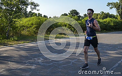 Athletic young man running in the nature. Urban healthy active lifestyle Editorial Stock Photo