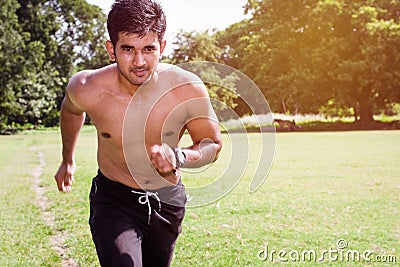 Athletic young man streching his legs in the sports ground. Healthy lifestyle , fitness and sports concept. Stock Photo