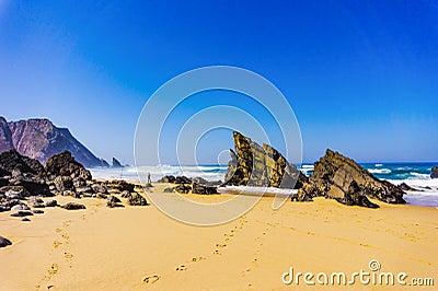 Atlantic ocean rocky coastline of Adraga beach with fisherman. Portugal Stock Photo