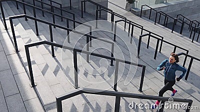 Atletische geschiktheidsvrouw die in stedelijke stad die met oortelefoons lopen aan muziek luisteren stock videobeelden Atletische geschiktheidsvrouw die in stedelijke stad die met oortelefoons lopen aan muziek luisteren stock videobeelden