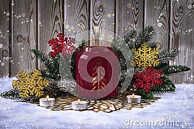 Atmospheric Christmas candle holder with fire, with fir branches, Christmas balls and decorative snowflakes Stock Photo