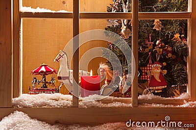 Atmospheric Christmas window sill decoration:snow,tre e,candle,rocking horse and carousel Stock Photo