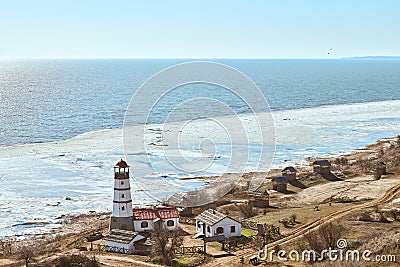 Atmospheric romantic view to white red lighthouse with farm utility houses in Merzhanovo Stock Photo